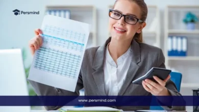 مدققة حسابات مبتسمة ترتدي نظارات وتمسك بجدول بيانات مالي وآلة حاسبة في مكتب، ترويجاً لوظيفة مدقق حسابات براتب ومزايا قوية عبر Persmind.