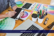 مصمم يعمل على لوحة رقمية بجانب عينات ألوان وأدوات تصميم على مكتب، في صورة تعبر عن وظيفة مصمم جرافيك أزياء في الكويت